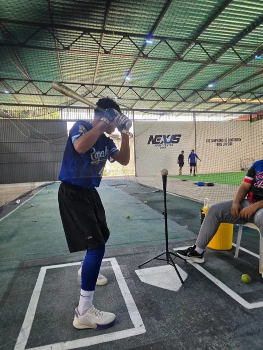 Joven practicando bateo en el tee en Nexus Sport Center